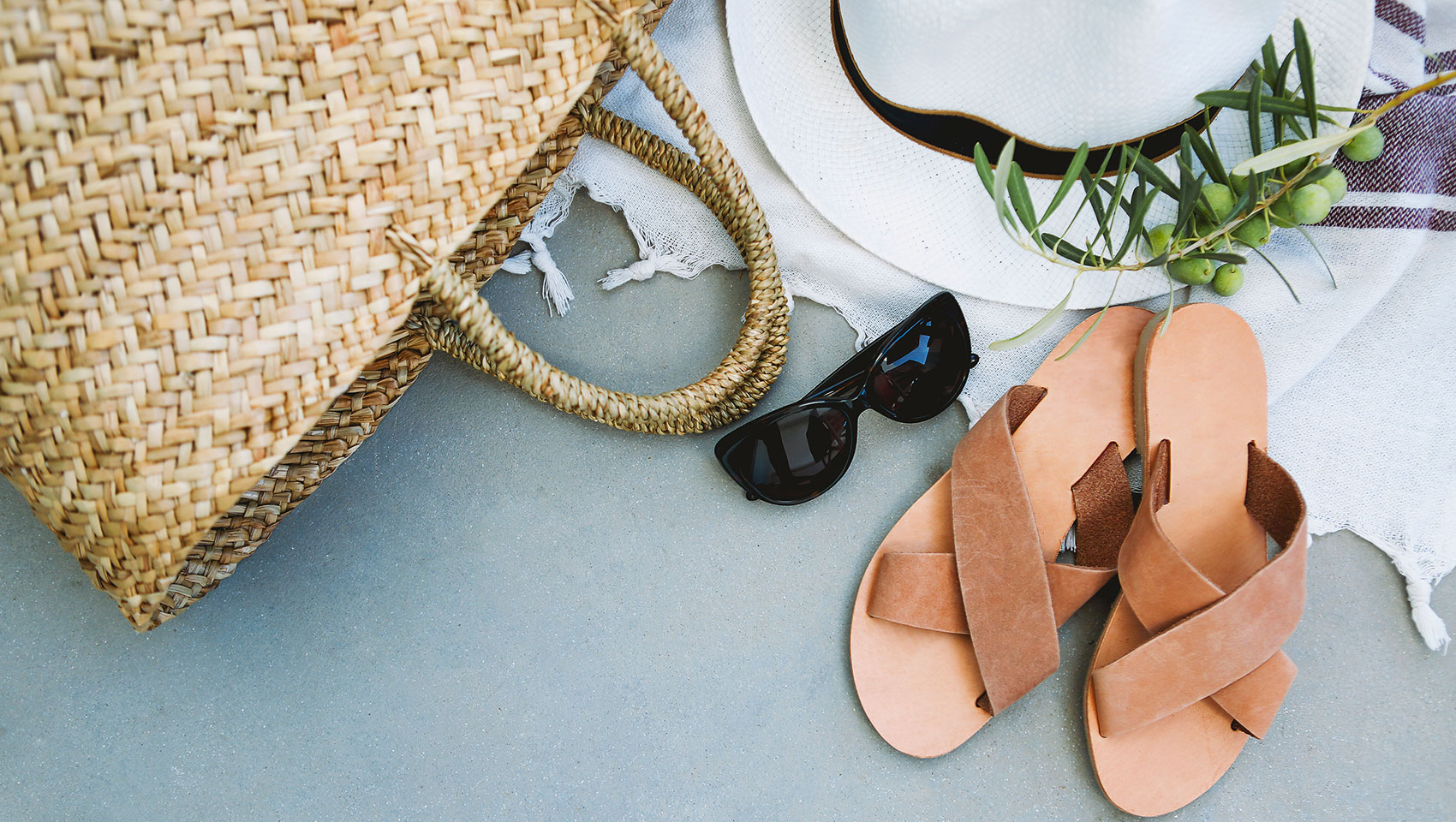 rattan bag, sunglasses, sandals, sun hat, picnic blanket, olives